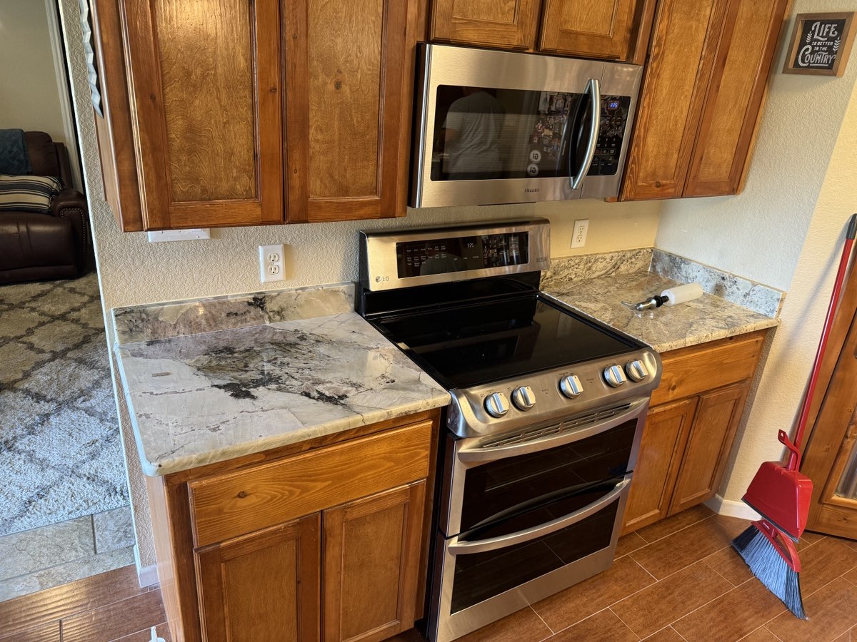 White Paradise granite kitchen countertop with farmhouse sink — Heart of Texas Granite & Marble Central Texas