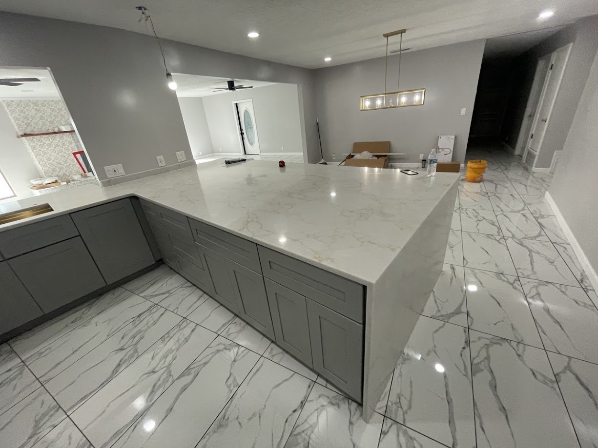 Milan Gold quartz kitchen island with gold and grey veining on grey shaker cabinets — Central Texas