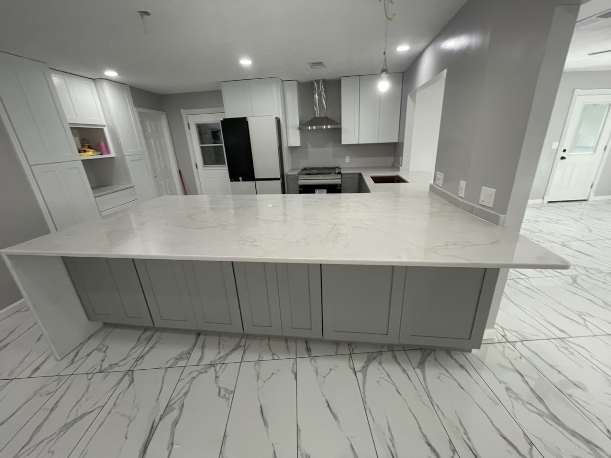 Milan Gold quartz full kitchen peninsula view with white upper cabinets — Central Texas installation